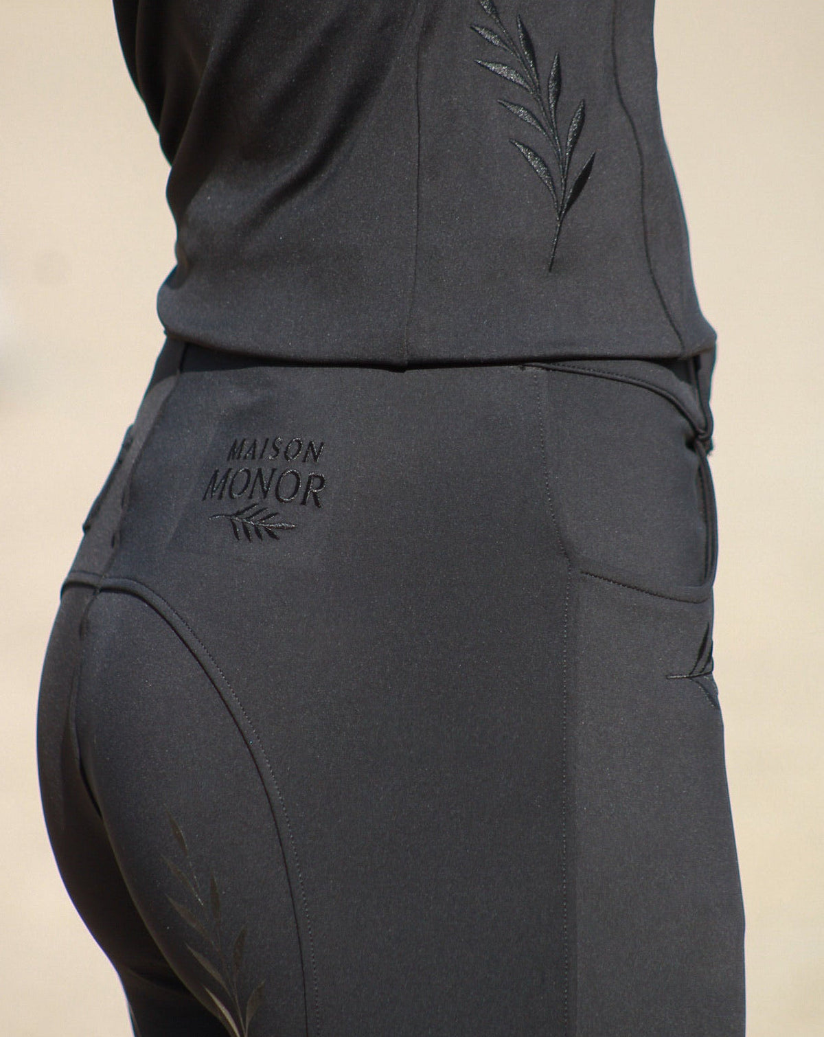 Dos de l'ensemble Ébène noir Maison Monor : logo et broderies lauriers ton sur ton